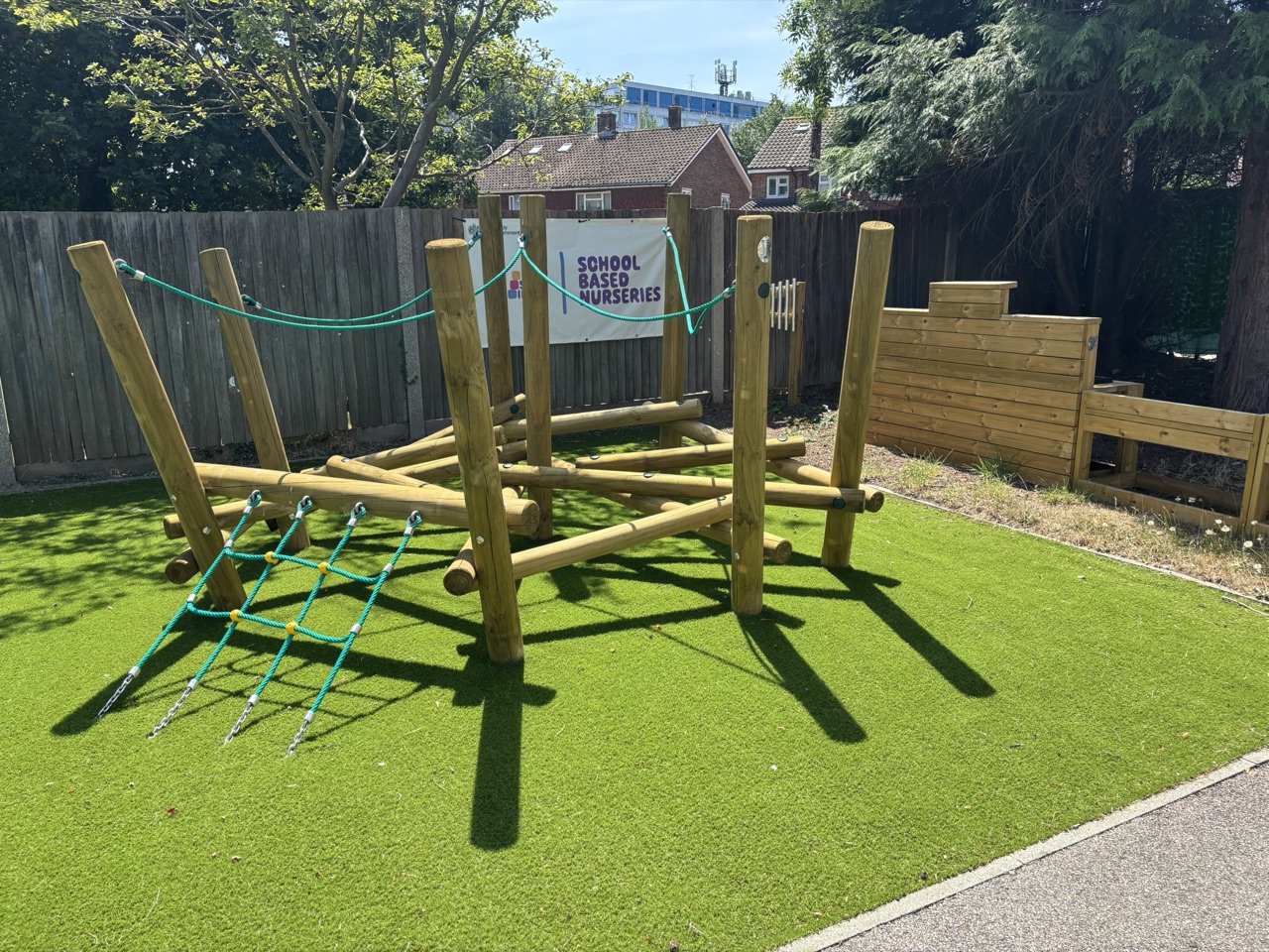 Outdoor play area with wooden climbing frame at West Green Day Nursery & Pre-School